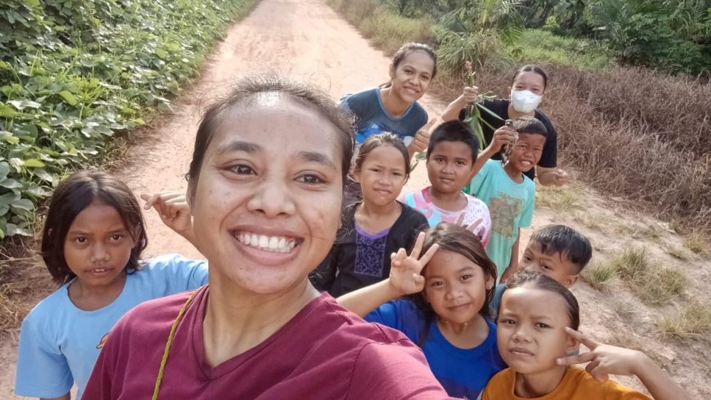 Pagi itu, Sabtu,  masih kelabu saat kami mulai melangkah. Namun, bukan dingin atau kantuk yang terasa. Di Batu Payung, anak-anak sudah berkumpul dengan mata berbinar, tubuh mungil mereka penuh energi yang meluap-luap. Bukan sekadar berlari, pagi itu adalah panggilan untuk tertawa, untuk saling menyapa, dan untuk memulai sesuatu yang sederhana namun luar biasa: kebersamaan.
Udara desa yang masih perawan menyambut kami. Embun masih menggantung di ujung daun ilalang, sementara sang fajar perlahan merangkak naik dari ufuk timur, cahayanya hangat, bersahabat, seolah ikut membangkitkan semangat. Kami berlari di jalan yang dikelilingi hamparan alam hijau. Suasana sederhana, tapi terasa begitu kaya.
Sejak pukul enam, anak-anak sudah berjejer di sepanjang jalan. Ada yang memakai sandal jepit, ada pula yang nekat berlari tanpa alas. Kami tidak menunggu semua sempurna. Sambil terus melangkah, kami mengajak anak-anak lain yang masih malu-malu berdiri di teras rumah mereka. Dalam hitungan menit, rombongan kecil itu tumbuh seperti sungai yang mendapat banyak anak cabang.
Rute jogging kami tidak panjang, tetapi indah. Anak-anak berlari riang; ada yang cepat bagaikan kancil kecil, ada yang lebih suka berjalan santai sambil bergandengan tangan. Namun apapun gaya mereka, semuanya menikmati momen itu. Mereka saling bersorak, "Ayo, jangan berhenti, tinggal sedikit lagi!"
Di tengah perjalanan, beberapa anak mulai terlihat kelelahan. Napas mereka memburu, langkah mulai melambat. Namun tidak seorang pun menyerah, yang lebih kuat justru lambat, menarik tangan temannya, membagi semangat dengan kalimat sederhana: "Kita bareng-bareng, ya." Saat itu, saya melihat sebuah pelajaran berharga yang tidak diajarkan di papan tulis: bahwa kekuatan sejati bukanlah siapa yang tercepat, melainkan siapa yang mau menunggu dan mengangkat teman di sisinya.
Setelah garis finis, kami beristirahat. Beberapa anak duduk lesu di atas batu besar, sebagian lain masih tertawa kecil sambil minum air putih dari botol bekas minuman kemasan. Keringat membasahi pelipis mereka, tapi tidak ada satu pun wajah yang tampak menyesal. Kebersamaan terasa hangat, bahkan lebih hangat dari cahaya matahari yang kini mulai meninggi.

Saya sadar, ini bukan sekadar olahraga. Jogging pagi bersama anak-anak Batu Payung mengajarkan saya tentang makna kecil yang besar. Bahwa kedekatan tidak harus dibangun dengan acara megah atau biaya besar, cukup dengan melangkah bersama, menyapa, menjemput, dan tidak meninggalkan siapapun di tengah jalan.
Kegiatan sederhana seperti ini, jika dilakukan secara rutin, bukan hanya menjaga kesehatan jantung dan otot. Lebih dari itu, ia merawat jiwa, membangun karakter, dan menenun kembali jejaring sosial yang mungkin mulai rapuh. Di Batu Payung, langkah-langkah kecil di pagi hari ternyata mampu membawa perubahan nyata: anak-anak yang awalnya hanya tetangga, perlahan menjadi sahabat yang saling peduli.

Penulis: Aprilia Yeyen, Aspiran Gembala Baik

